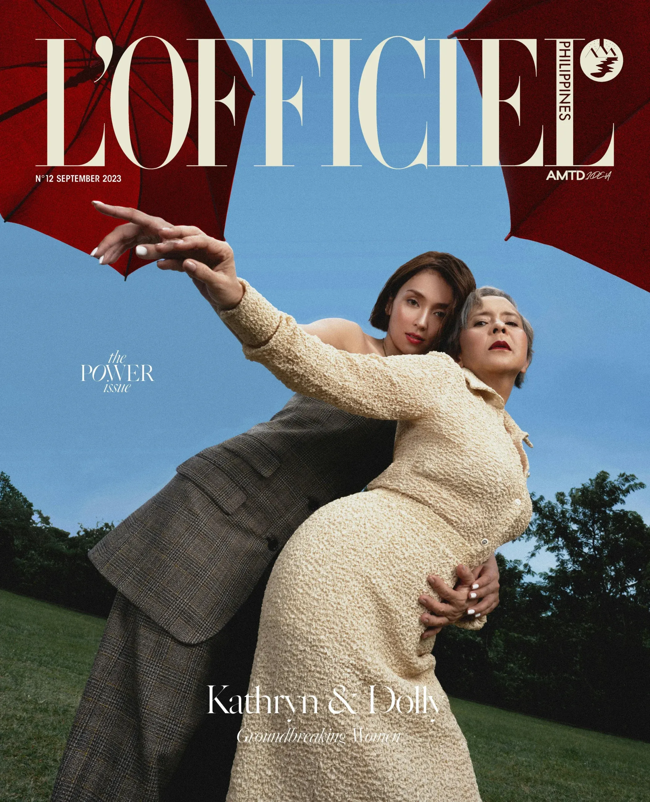 Magazine cover with the masthead “L’OFFICIEL” above two people in neutral-toned outfits posed outdoors.