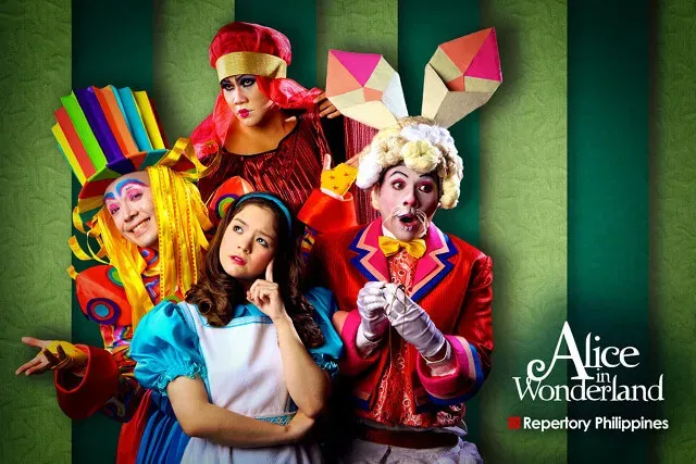 Promotional artwork for a stage production of “Alice in Wonderland” showing costumed performers in colorful, whimsical outfits.