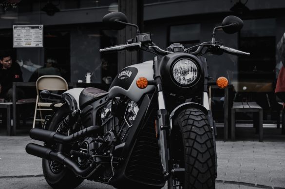 Photo of a parked motorcycle with chrome detailing in a dim industrial setting.