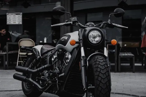 Photo of a parked motorcycle with chrome detailing in a dim industrial setting.